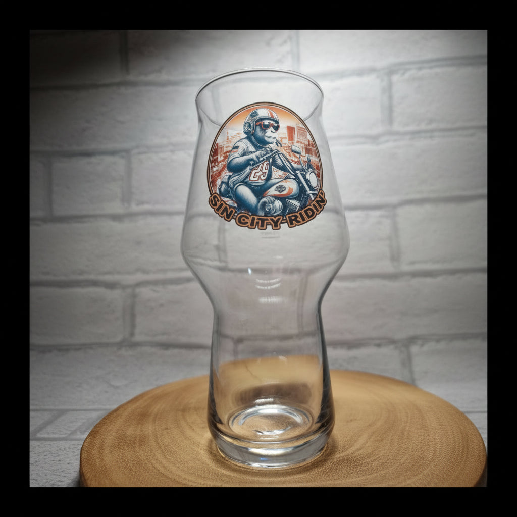 Glass of beer with a 'Sin City Kombucha' label on a wooden surface and white brick wall background