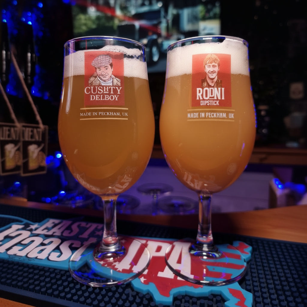 A pint beer glass with a design inspired by Rodney 'Madri' from the Only Fools and Horses sitcom, placed on a table in a pub setting.