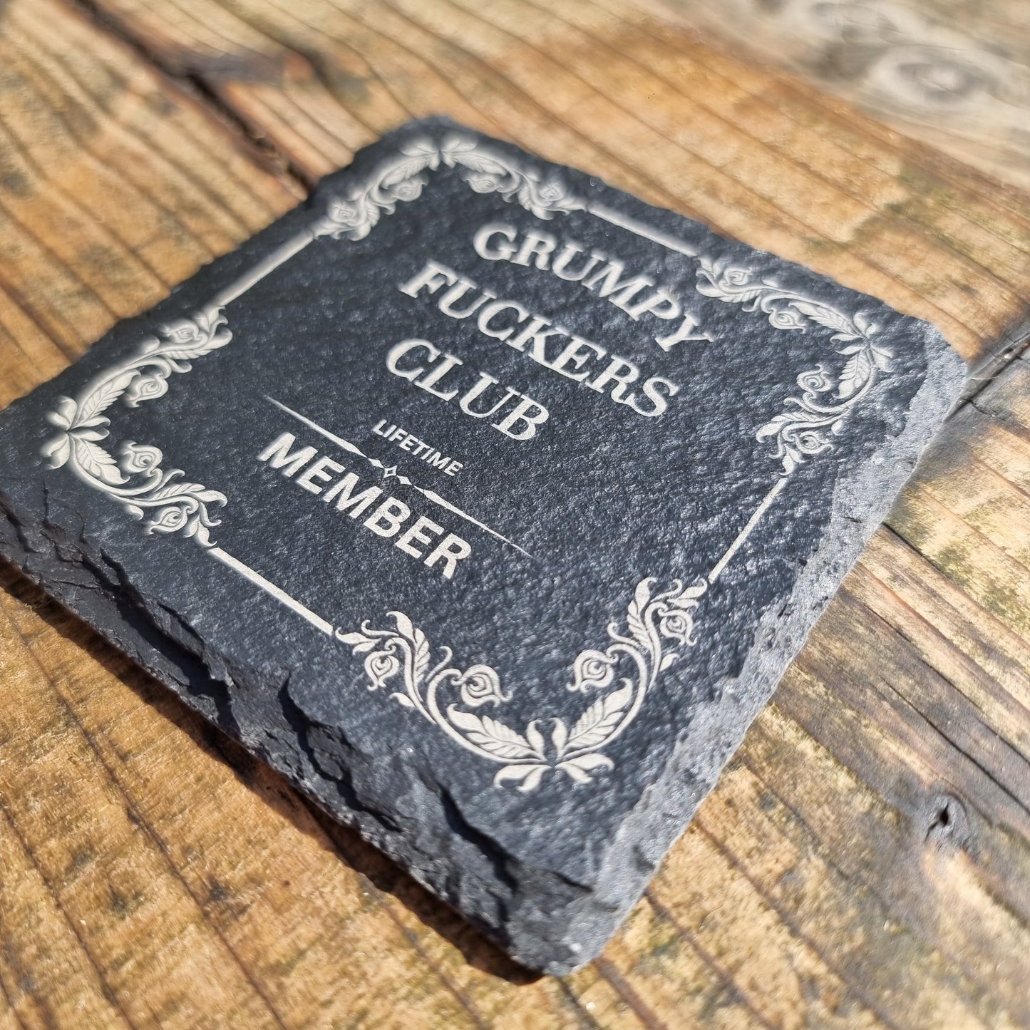 Engraved slate sign reading “Grumpy F*ckers Club Lifetime Member” with decorative vintage border, laser engraved on natural wood plaque with rustic finish.
