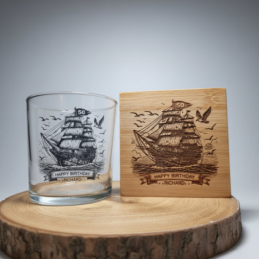 Personalised rum glass with ship design next to laser engraved bamboo coaster — custom name and age, nautical gift for him