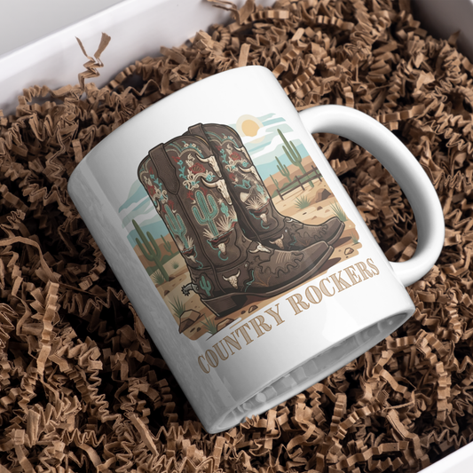 Personalised cowboy boots coffee mug with custom name engraving
displayed in white gift box with brown kraft paper, ready for gift
giving, featuring western desert landscape and ornate boot artwork