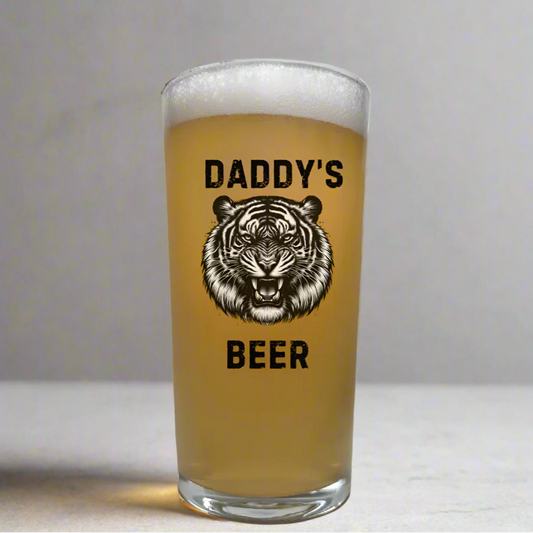Personalised animal pint glass featuring bold fierce tiger illustration with custom text above and below, fully customisable beer glass gift with choice of animal and any personalised wording, shown filled with golden beer on neutral background