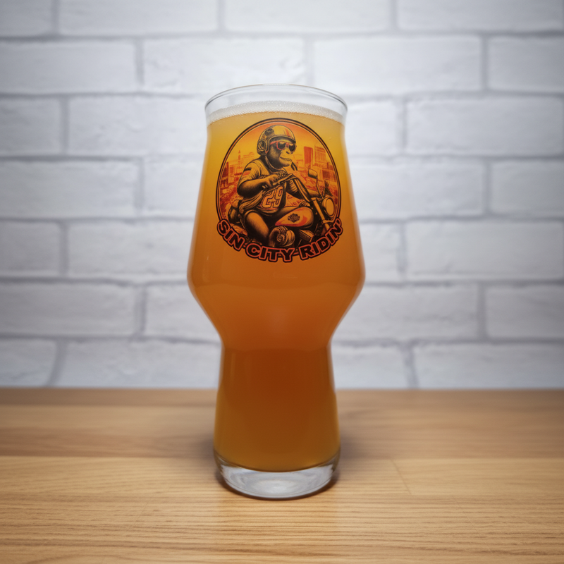 Glass of beer with a 'Sin City Kombucha' label on a wooden surface and white brick wall background