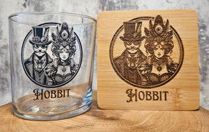 Glass tumbler and wooden coaster with 'Hobbit' design on a wooden surface.