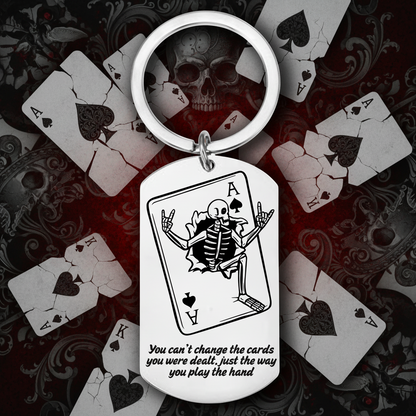 Keychain with a skeleton playing cards design and text on a white background