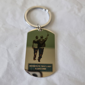 Keychain with reflective tag showing two people walking and text 'Moments That Last A Lifetime' on a white background.