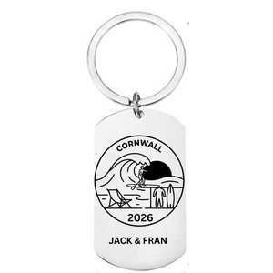 Personalised Cornwall holiday laser engraved stainless steel dog tag keyring with surf and beach scene personalised with year and names on white background