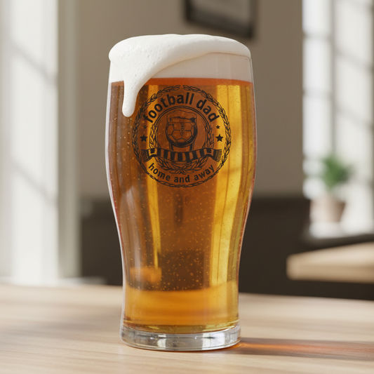 Football Dad Home and Away personalised pint glass featuring circular engraved badge design with foaming beer glass, football, laurel wreath, stars and supporter scarf detail on white background, perfect Father's Day gift for football dads