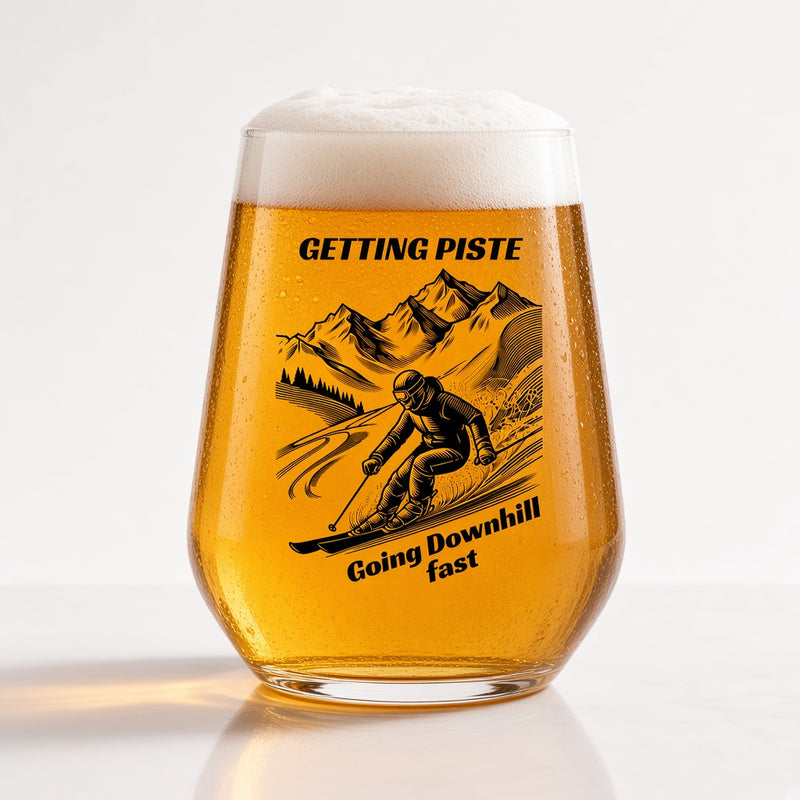 A clear pint glass filled with golden beer and topped with white foam, featuring a black graphic of a skier in front of mountains with the text 'GETTING PISTE' and 'Going Downhill fast'.