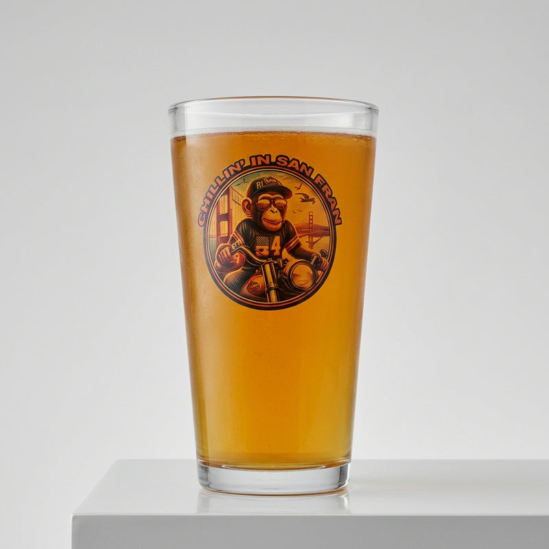 A glass of beer with a logo that includes a monkey riding a motorcycle across the Golden Gate Bridge.