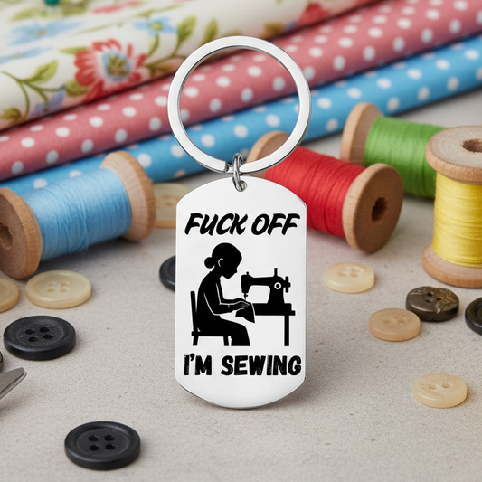 Keychain with a graphic of a person sewing and text on a white background