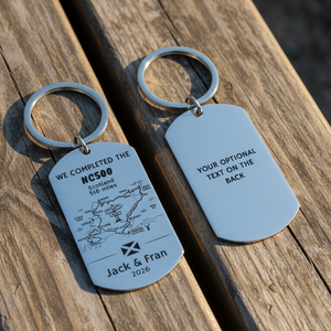 Two keychains with engraved text and a map, one showing 'WE COMPLETED THE NC500 Scotland 516 miles' and the other with space for additional text.