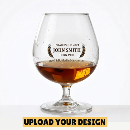 Personalised 250ml brandy balloon glass with custom uploaded John Smith Established 2024 design filled with golden brandy
