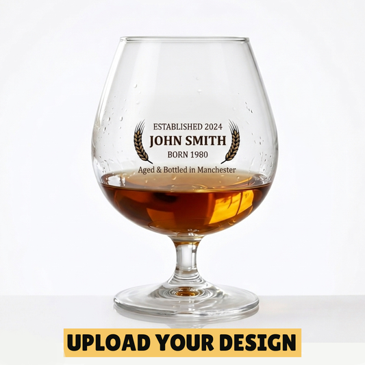 Personalised 250ml brandy balloon glass with custom uploaded John Smith Established 2024 design filled with golden brandy
