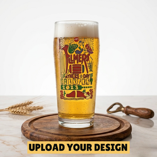 Personalised 568ml tall slim pint glass with custom uploaded Father's Day Beerfest design filled with golden lager on wooden board