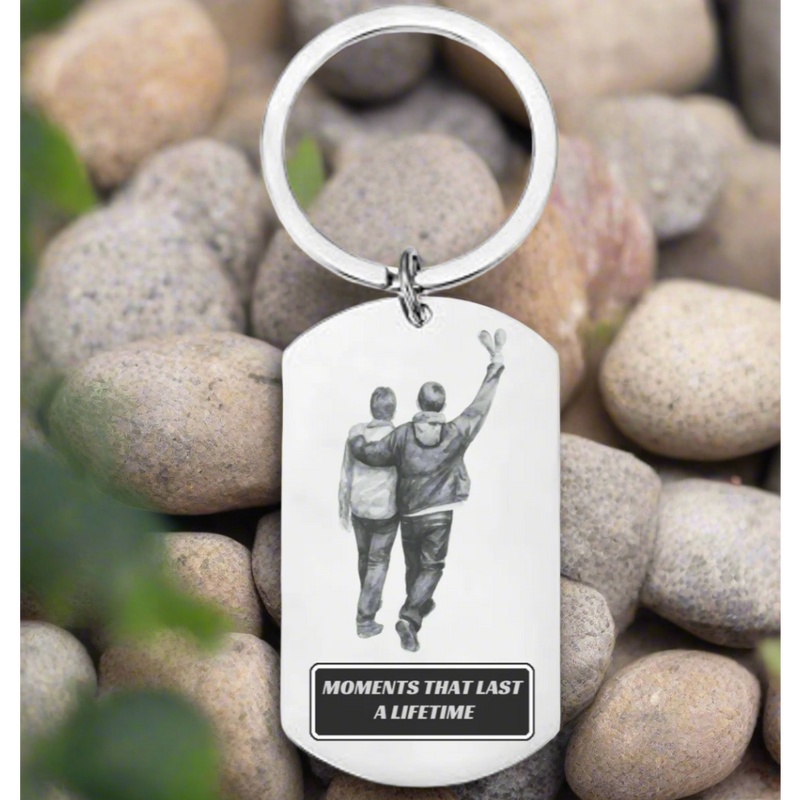 Personalised britpop engraved stainless steel dog tag keyring showing two brothers walking with one arm raised, with the text "Moments That Last A Lifetime", resting on pebbles