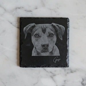Personalised pet portrait coaster on marble surface — natural slate with engraved dog illustration