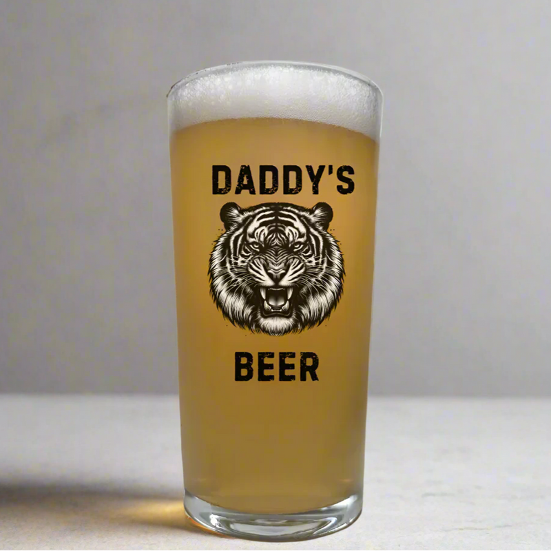 Personalised animal pint glass featuring bold fierce tiger illustration with custom text above and below, fully customisable beer glass gift with choice of animal and any personalised wording, shown filled with golden beer on neutral background