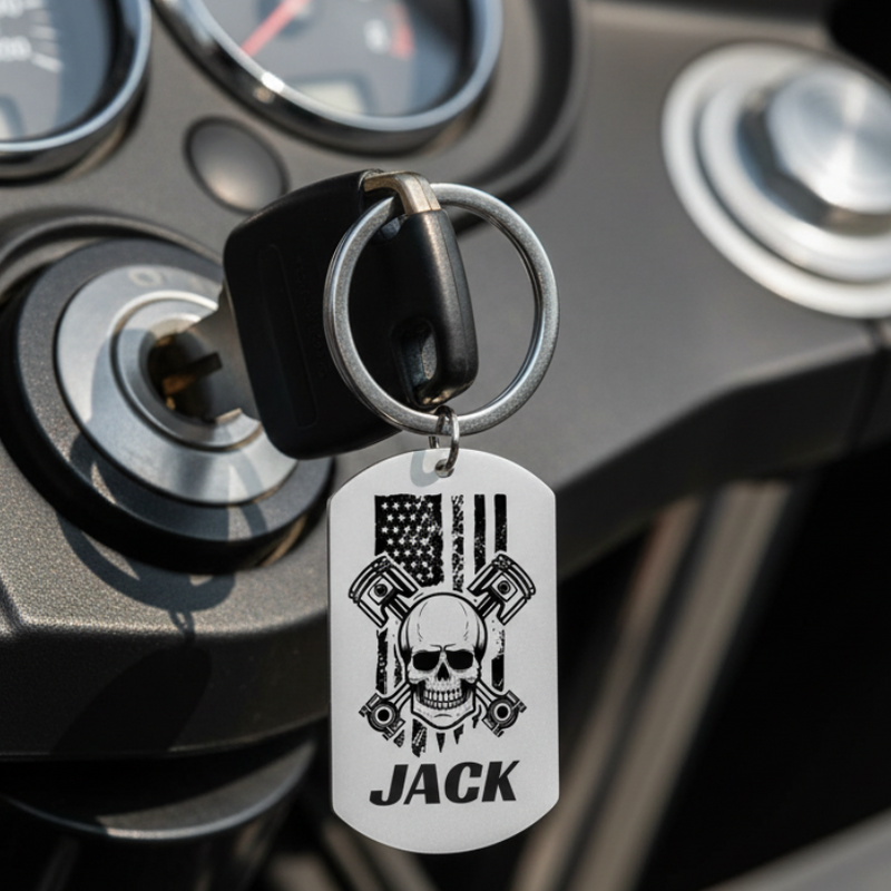 Skull and crossbones dog tag keychain with pistons, American flag background, custom name on front, engraved message on back