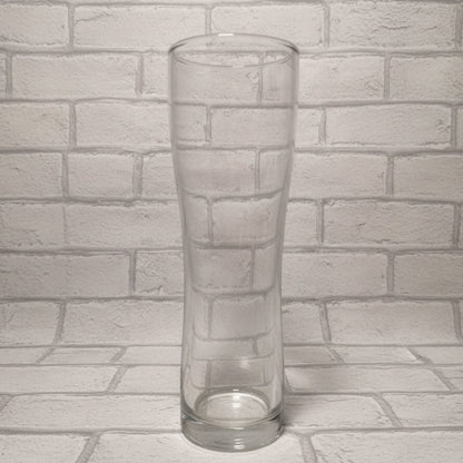 Plain 1-pint Aspen schooner beer glass on wooden surface shown before custom design is applied — wide-bodied shape with handle-free design
