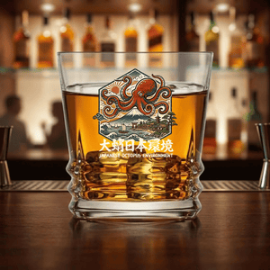 custom Japanese Octopus Environment whiskey rocks glass filled with bourbon on a bar counter, featuring ukiyo-e art design with red octopus, Mount Fuji, waves and Japanese kanji engraving