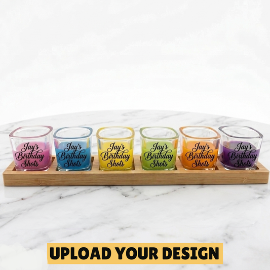 personalised set of six 60ml shot glasses on laser engraved bamboo paddle showing Jay's Birthday Shots design in rainbow coloured drinks on marble surface