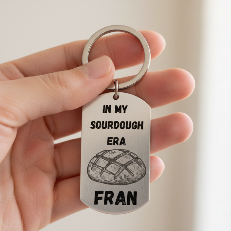 Hand holding a keychain with 'In my sourdough era Fran' text and bread graphic.