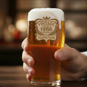 Close-up detail of laser-engraved birthday beer glass showing sharp 
"Aged to Perfection - [Year]" text with decorative vintage frame design 
on premium borosilicate glass