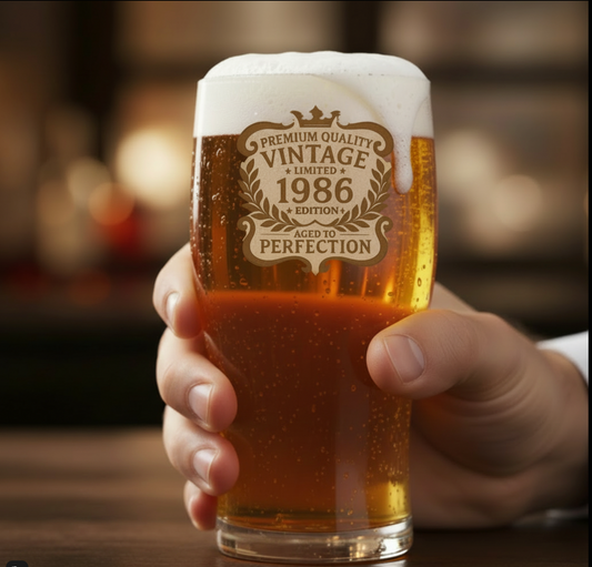 Close-up detail of laser-engraved birthday beer glass showing sharp 
"Aged to Perfection - [Year]" text with decorative vintage frame design 
on premium borosilicate glass