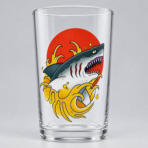 Custom printed pint glass featuring a traditional tattoo-flash shark and ocean wave illustration